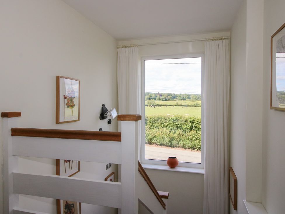 A staircase with a window and artwork at Plum Hill, Morda, near Oswestry