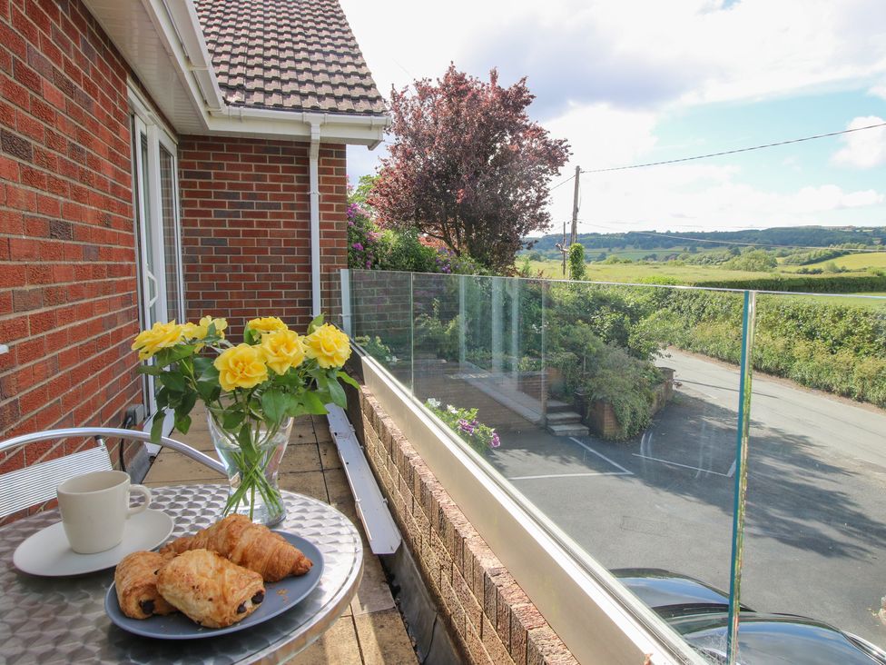 An outdoor patio with flowers and pastries at Plum Hill in Morda, near Oswestry