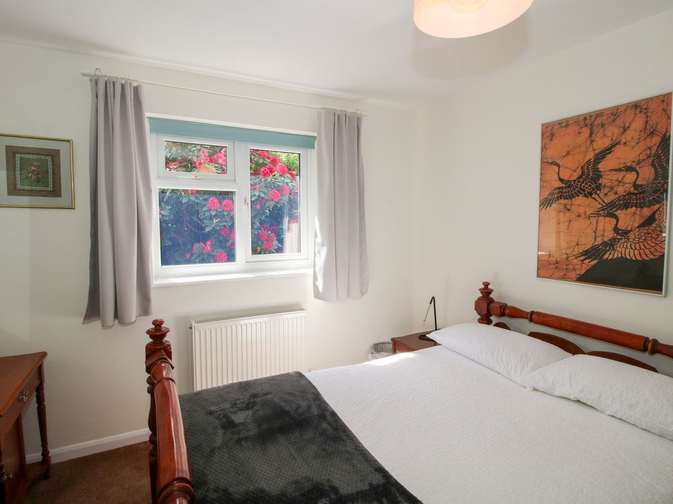 A bedroom with a bed, nightstand, and window at Plum Hill, Morda, near Oswestry