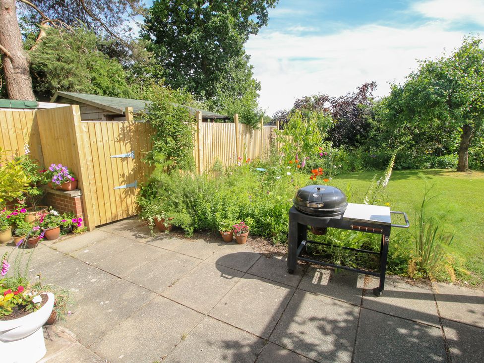 A garden with a grill and potted plants at Plum Hill in Morda, near Oswestry