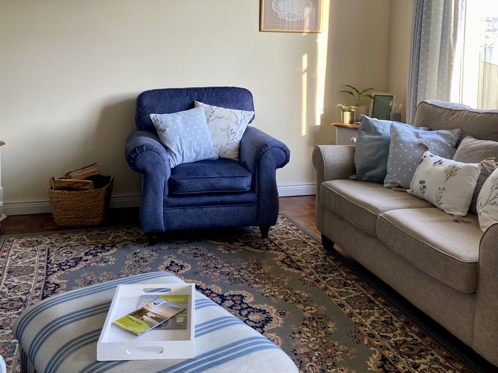 A living room with an armchair and sofa at Betty's Farm Cottage, Lack near Ederney, County Fermanagh