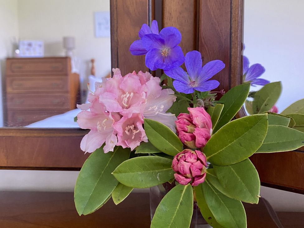 A flower arrangement on a wooden surface in a bedroom at Betty's Farm Cottage in Lack near Ederney, County Fermanagh