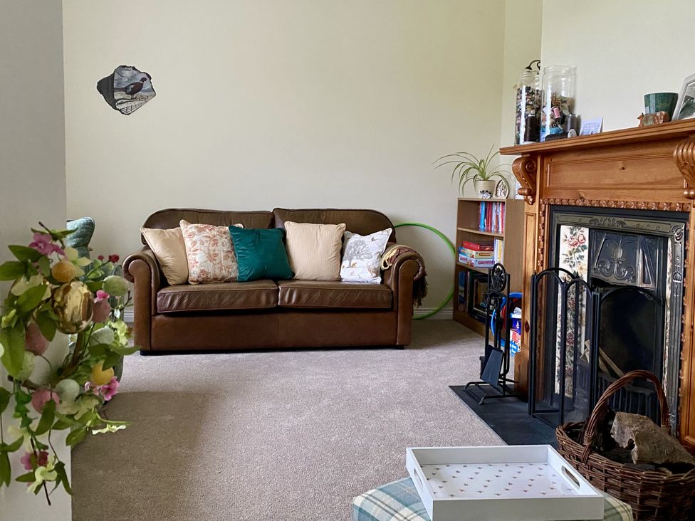 A living room with a sofa and fireplace at Betty's Farm Cottage, Lack near Ederney, County Fermanagh