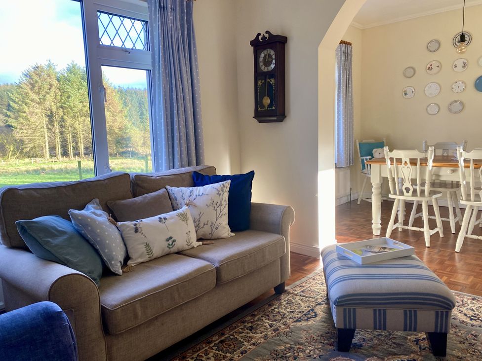 A living room with a sofa and dining area at Betty's Farm Cottage in Lack near Ederney, County Fermanagh