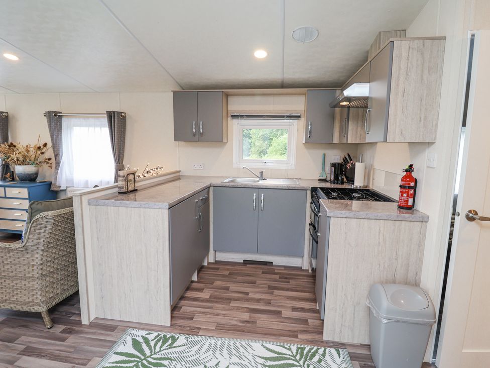 A kitchen with gray cabinets and a gas stove at The Hoot in Great Finborough near Stowmarket