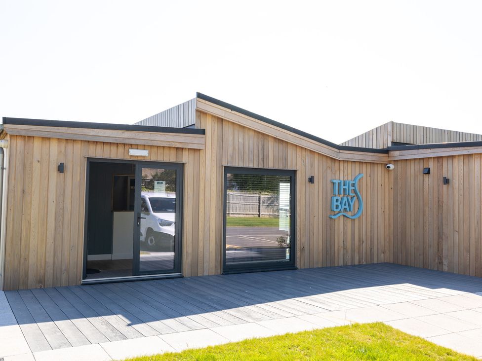 An exterior view of a wooden building with a sign at Lodge 65 at Riviera Bay Coastal Retreat in Brixham