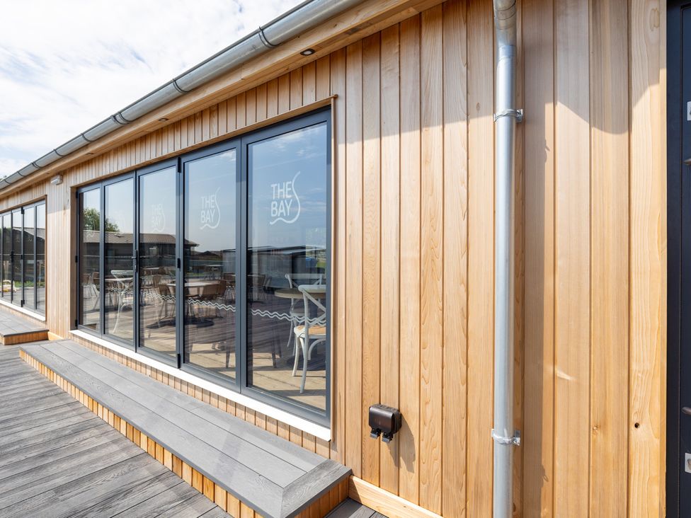 An outdoor area with wooden walls and large windows at Lodge 65 at Riviera Bay Coastal Retreat Brixham