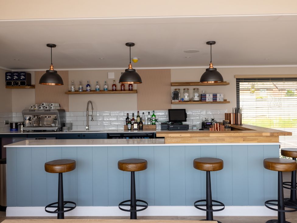 A kitchen with a bar counter and stools at Lodge 65 at Riviera Bay Coastal Retreat Brixham