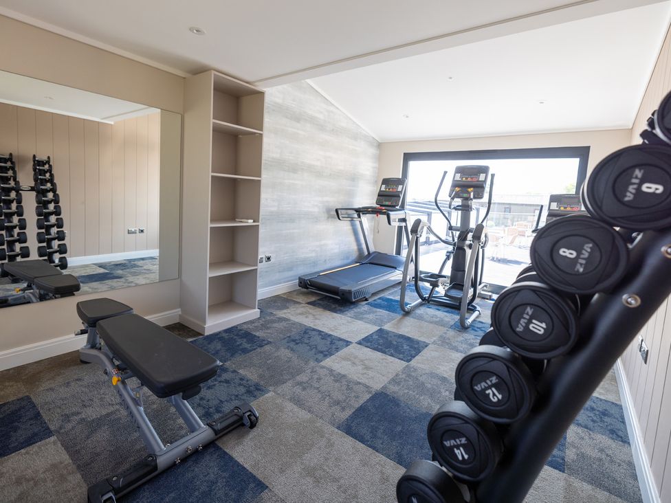 A gym with treadmill, elliptical machine and dumbbells at Lodge 65 at Riviera Bay Coastal Retreat in Brixham