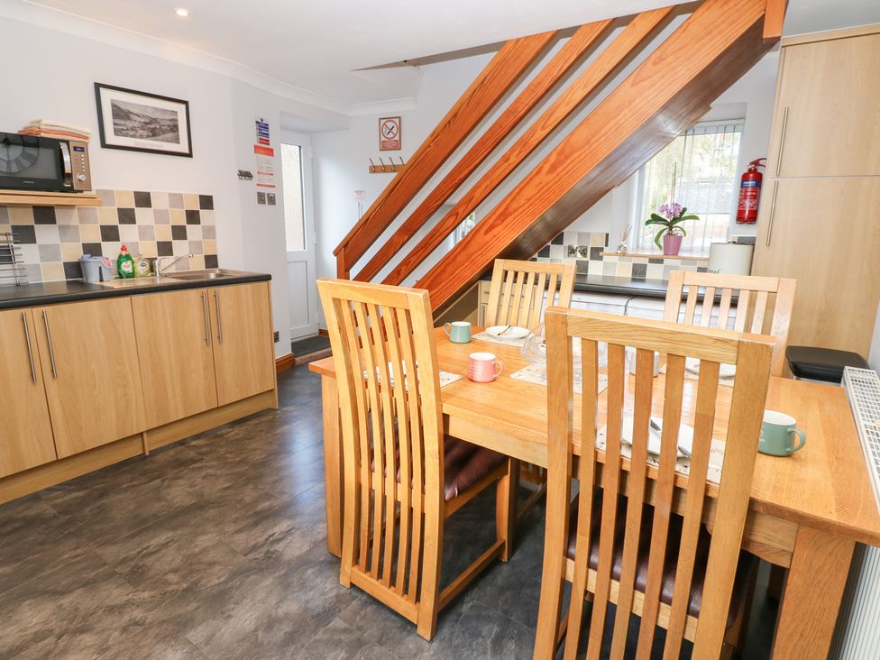 A kitchen with a dining table and microwave at Stoneleigh Cottage in Muker