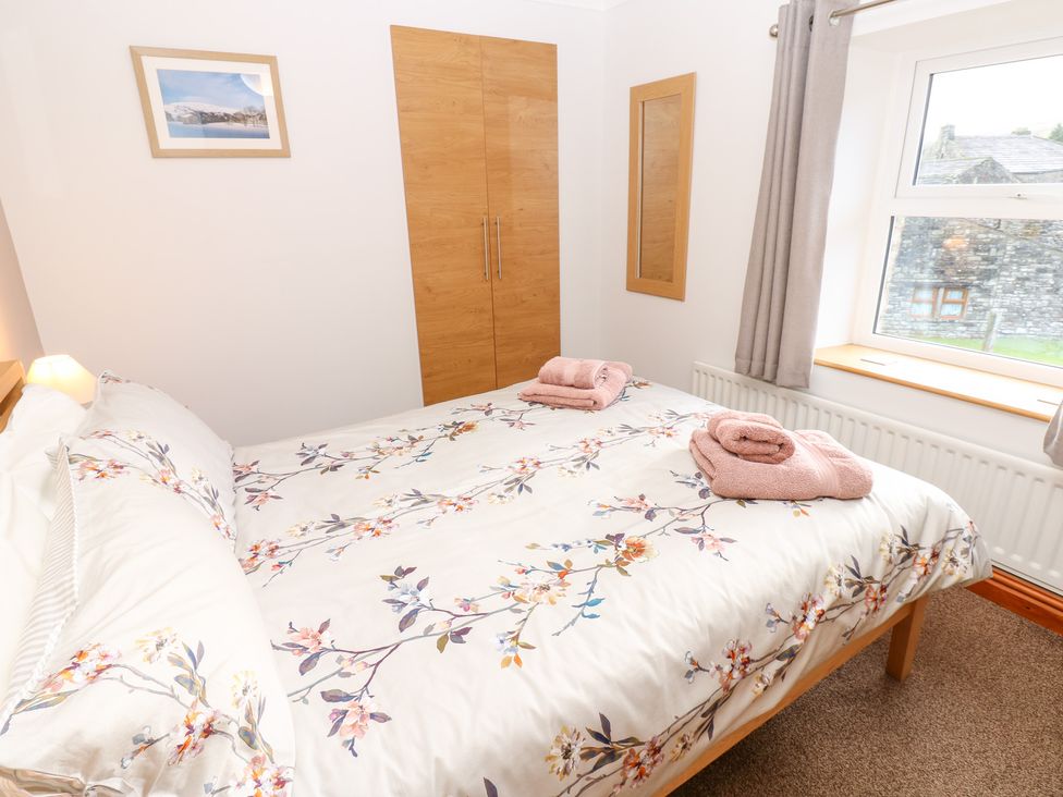 A bedroom with a bed and wardrobe at Stoneleigh Cottage in Muker