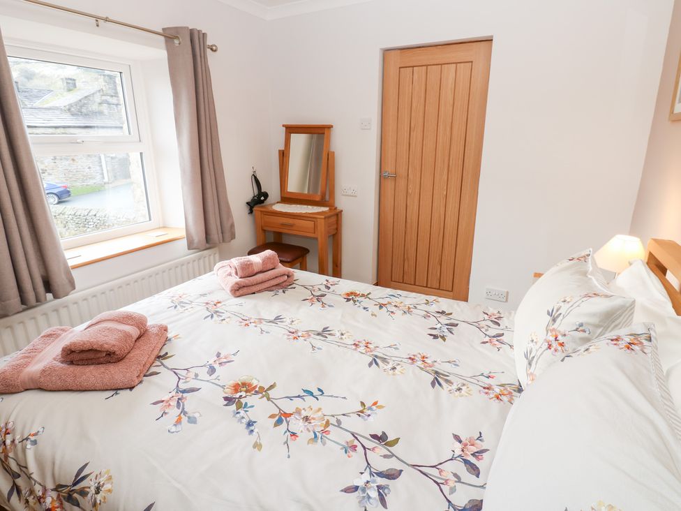 A bedroom with a bed and dresser at Stoneleigh Cottage in Muker