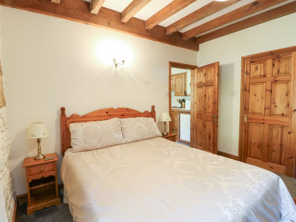 A bedroom with a bed and lamp at Royal Oak Farm Cottage in Betws-y-Coed