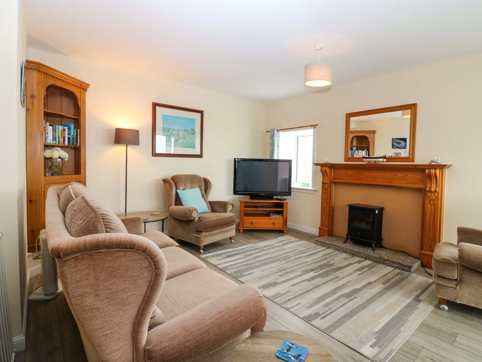A living room with a television and a fireplace at The Breakers in Newburgh, Aberdeenshire