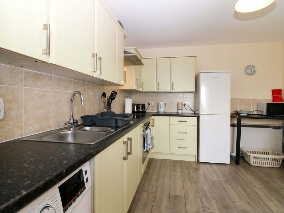 A kitchen with cabinets, sink, fridge, and appliances at The Breakers in Newburgh, Aberdeenshire