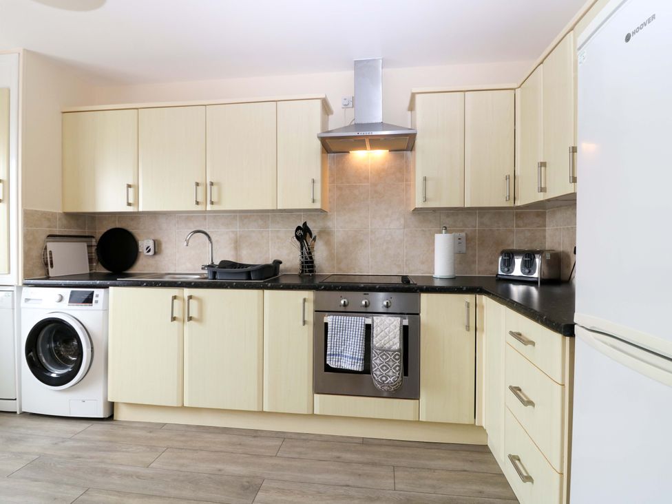 A kitchen with cabinets and appliances at The Breakers in Newburgh, Aberdeenshire