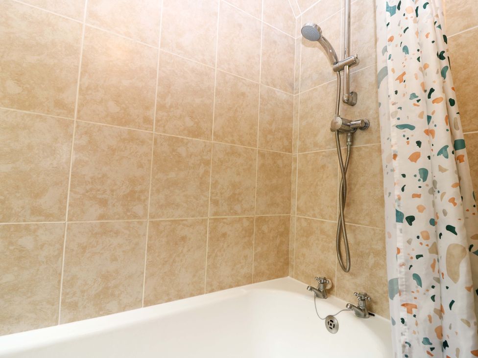 A bathroom with a shower and bathtub at The Breakers in Newburgh, Aberdeenshire