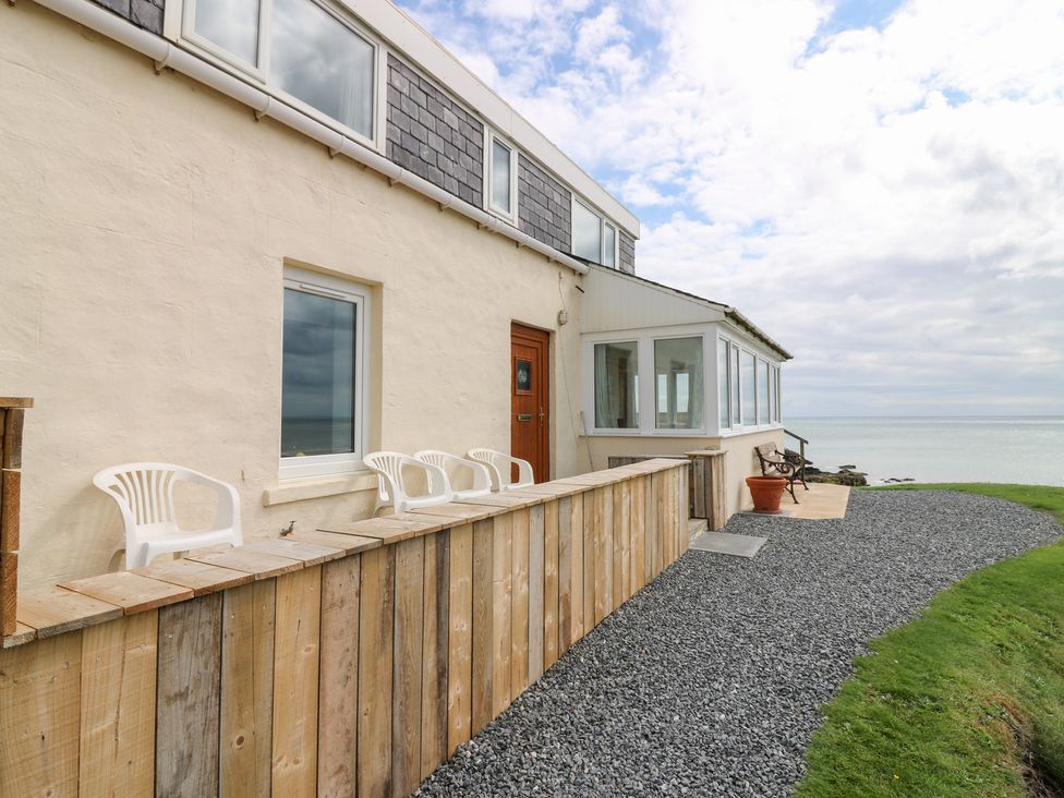 An exterior view of a building with chairs and gravel at The Breakers in Newburgh, Aberdeenshire