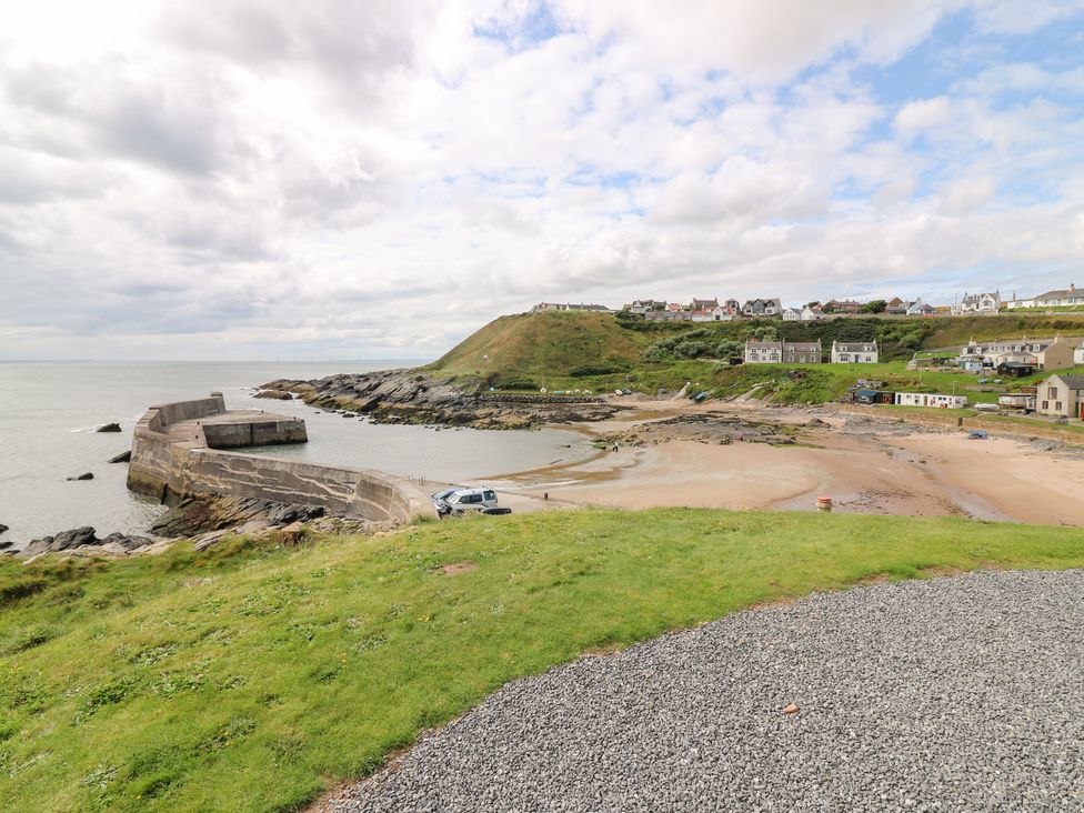 A beach view with a pier and houses at The Breakers Newburgh, Aberdeenshire