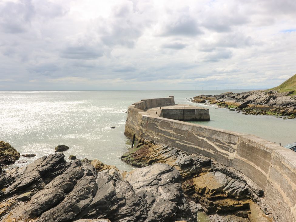 A concrete structure extending into the sea with rocks at The Breakers in Newburgh, Aberdeenshire