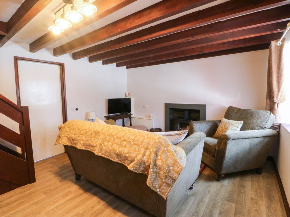 A living room with a sofa and television at Pant in Llanfairpwllgwyngyll