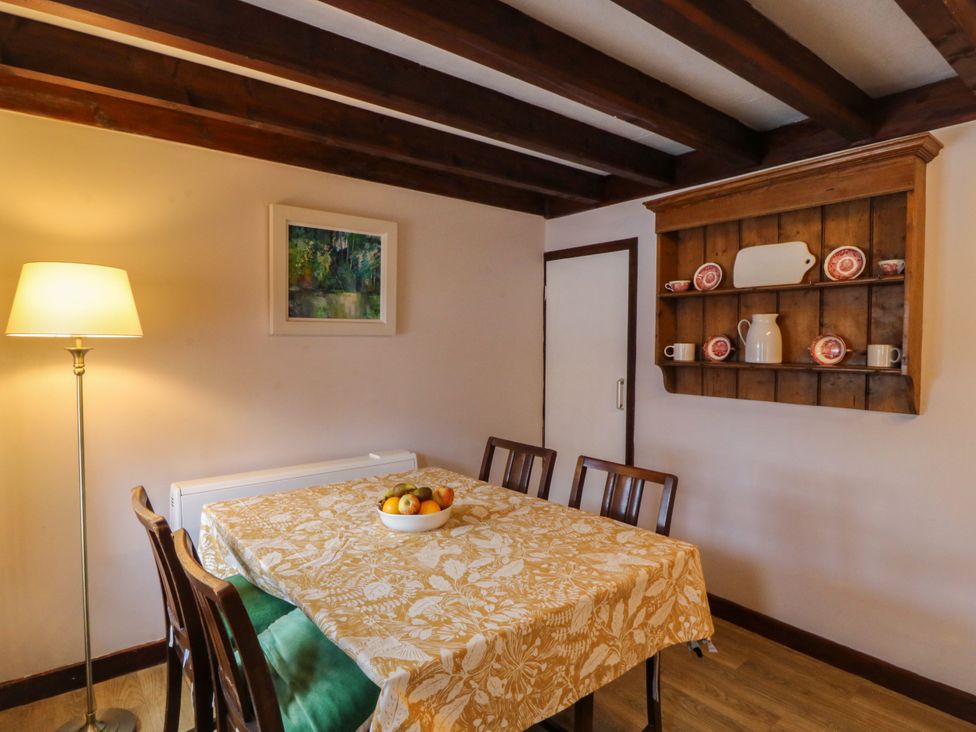 A dining room with a table and chairs at Pant in Niwbwrch (newborough)