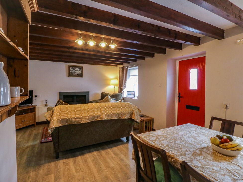 A living room with a sofa and table at Pant in Niwbwrch (newborough)