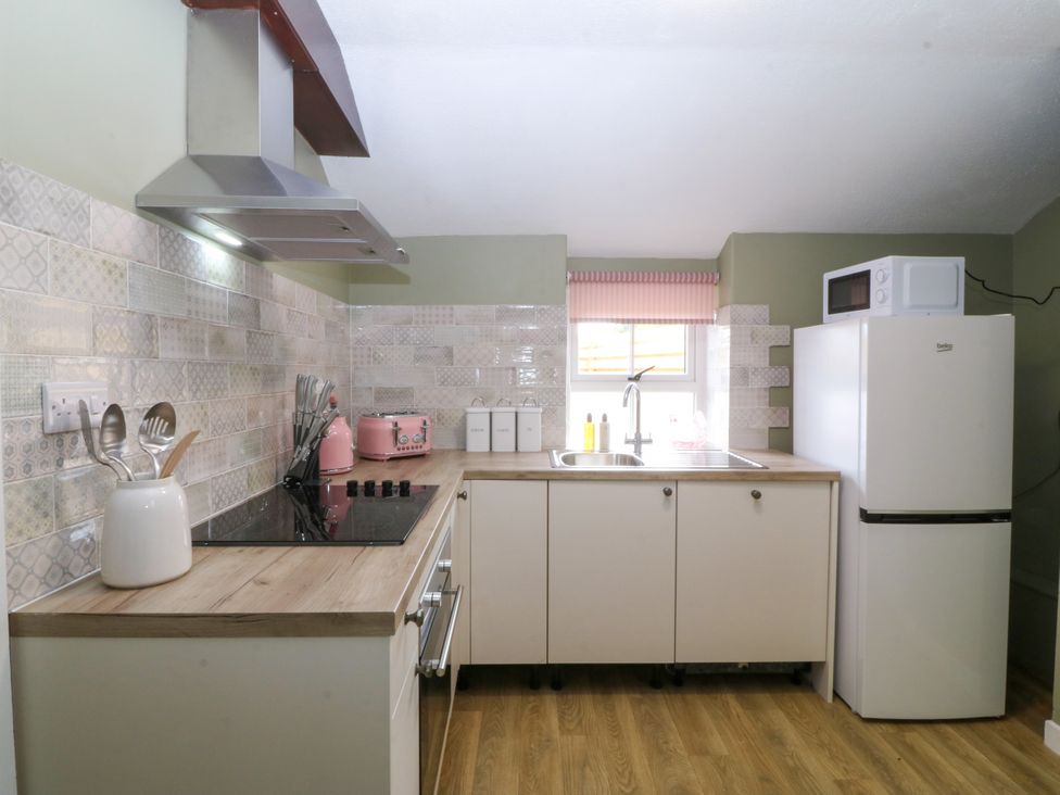 A kitchen with a stove and sink at Pant in Niwbwrch (newborough)