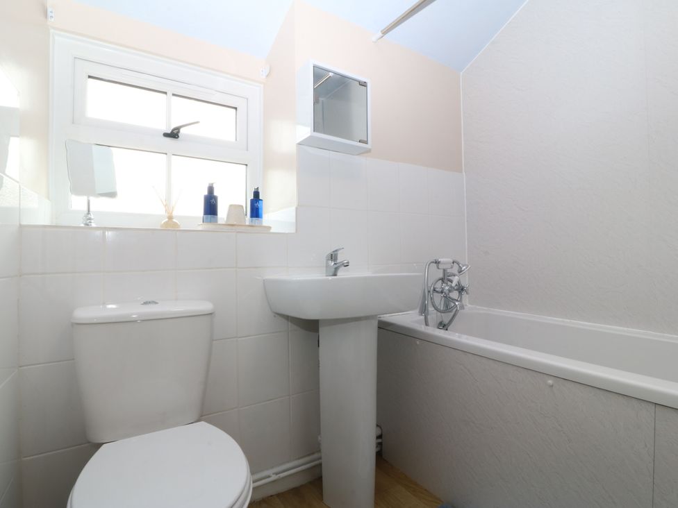 A bathroom with a sink, toilet, and bathtub at Pant in Niwbwrch (newborough)