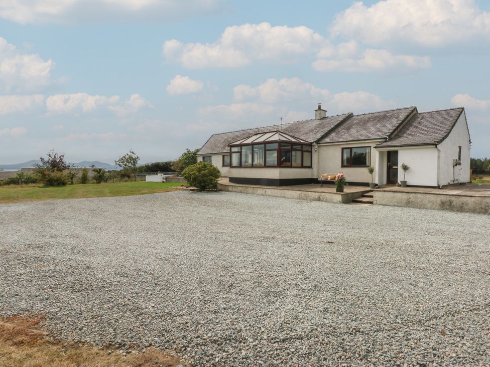 A house with a gravel area and plants at Tir Mawr in Llanfairpwllgwyngyll