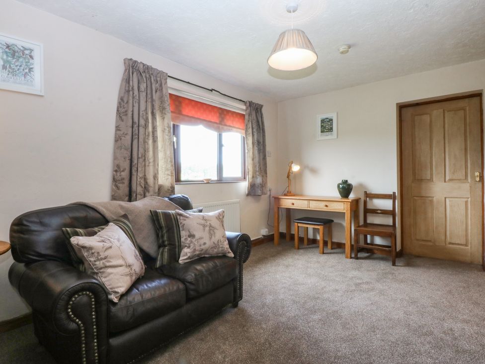 A living room with a sofa and side table at Tir Mawr in Llanfairpwllgwyngyll