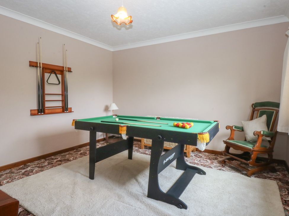 A snug with a pool table and a rocking chair at Tir Mawr in Llanfairpwllgwyngyll
