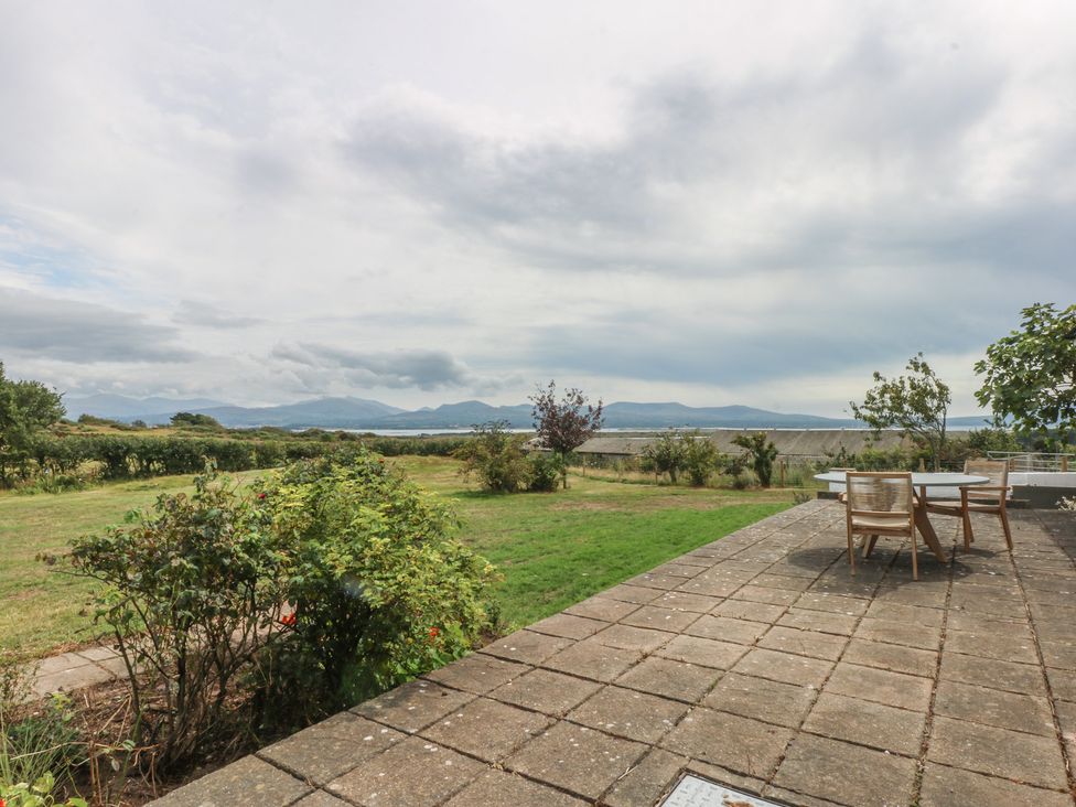 An outdoor area with a table and chairs at Tir Mawr in Llanfairpwllgwyngyll