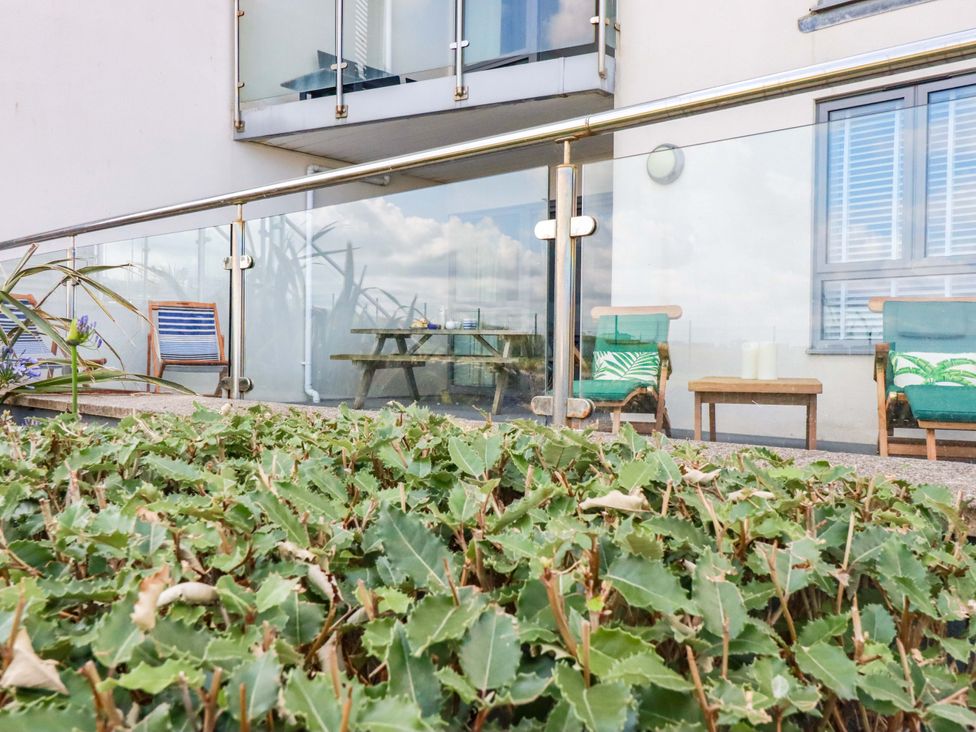 A balcony with chairs and a table at 4 Ocean Gate in Newquay