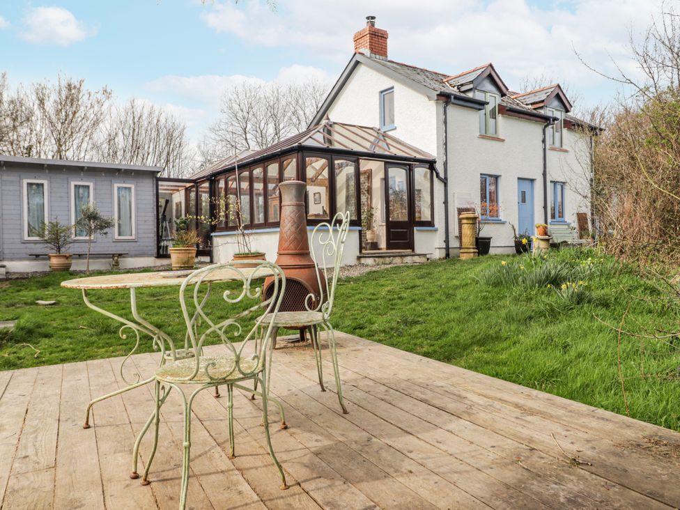 A garden with a house and conservatory at Pencestyll Cardigan