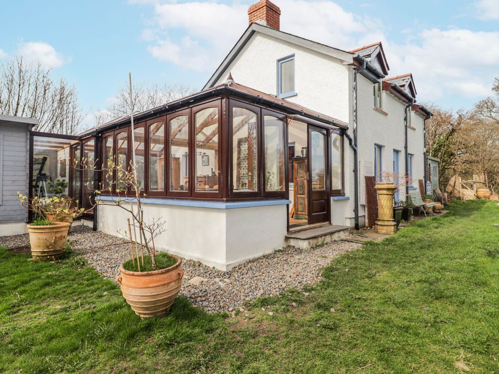 A conservatory with large windows and plants at Pencestyll in Cardigan