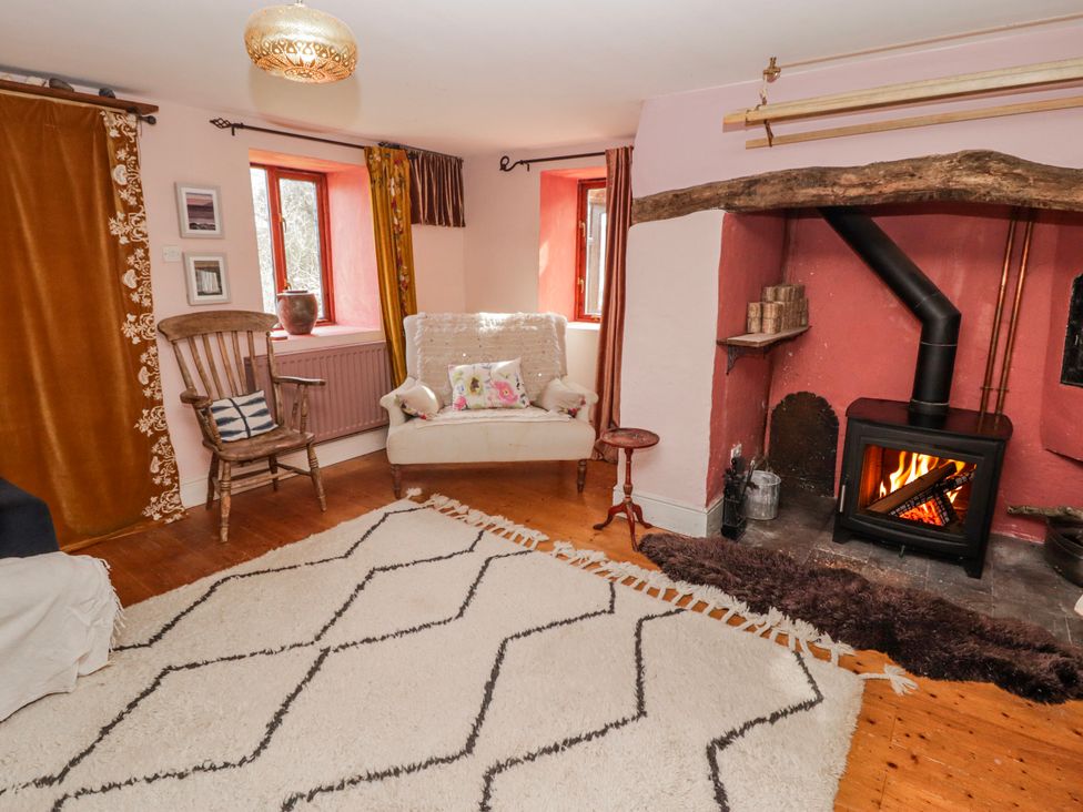 A living room with a fireplace and seating area at Pencestyll Cardigan