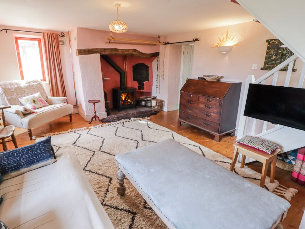 A living room with a fireplace and a sofa at Pencestyll in Cardigan