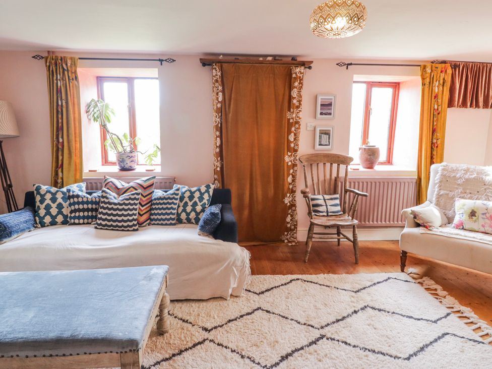 A living room with a sofa and chair at Pencestyll in Cardigan