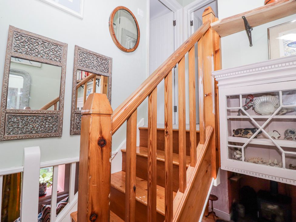A hallway with staircase and mirrors at Pencestyll in Cardigan