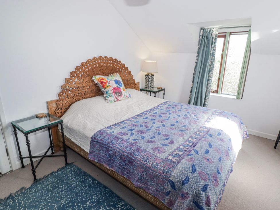 A bedroom with a bed and bedside table at Pencestyll in Cardigan
