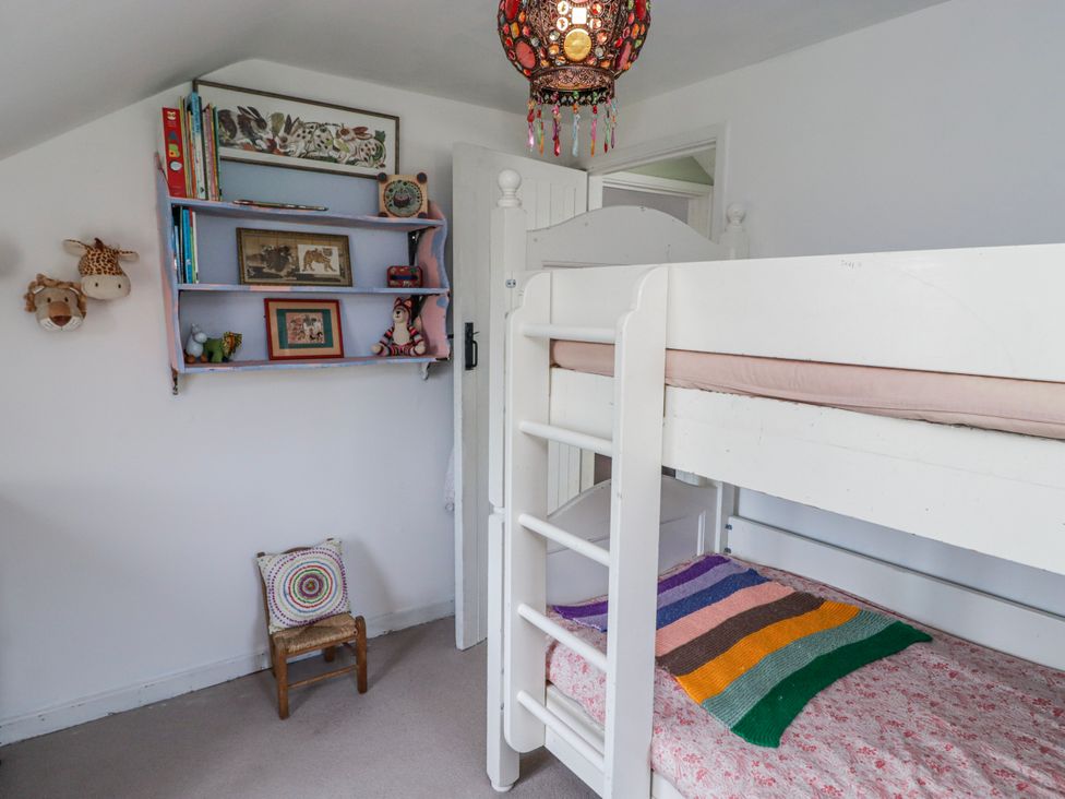 A bedroom with a bunk bed and a bookshelf at Pencestyll Cardigan