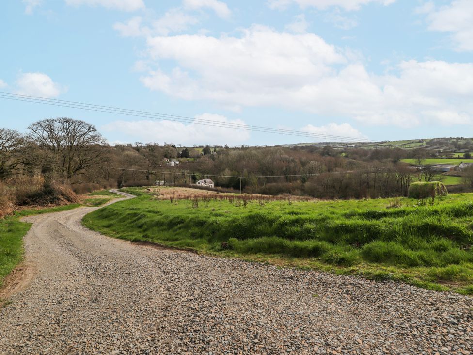 A winding gravel road through a rural landscape at Pencestyll in Cardigan