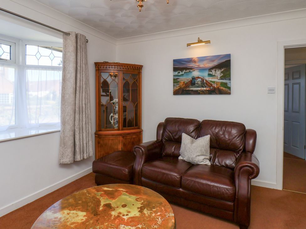 A living room with a sofa and cabinet at Castelian in Flamborough