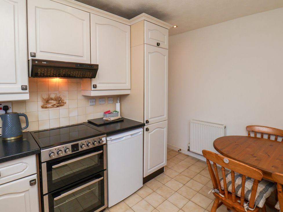 A kitchen with appliances and dining area at Castelian in Flamborough
