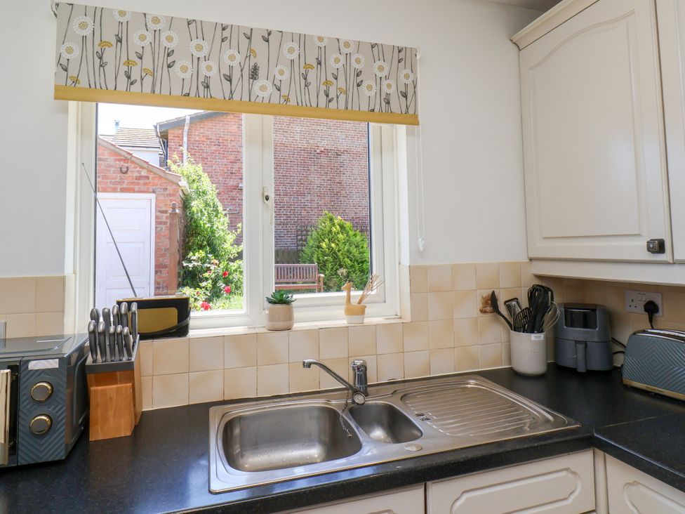 A kitchen with a sink and window at Castelian in Flamborough