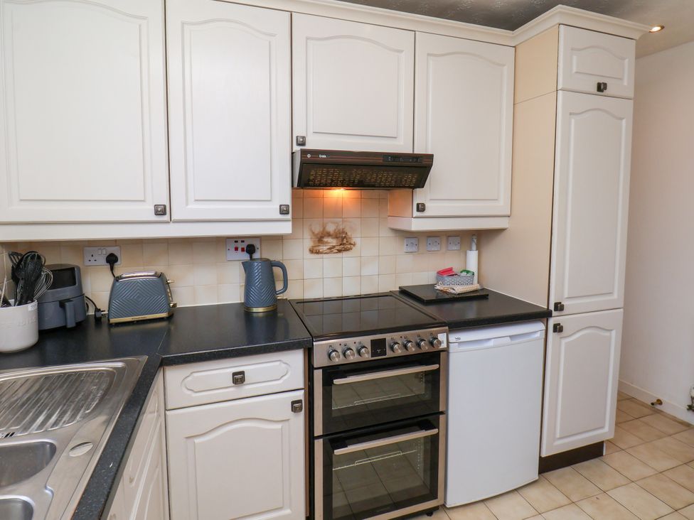 A kitchen with cabinets, oven, and utensils at Castelian in Flamborough