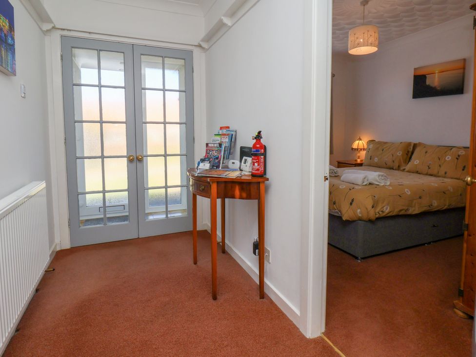 A hallway with a table and door leading to a bedroom at Castelian in Flamborough