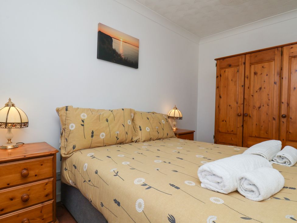 A bedroom with a bed and wooden furniture at Castelian in Flamborough