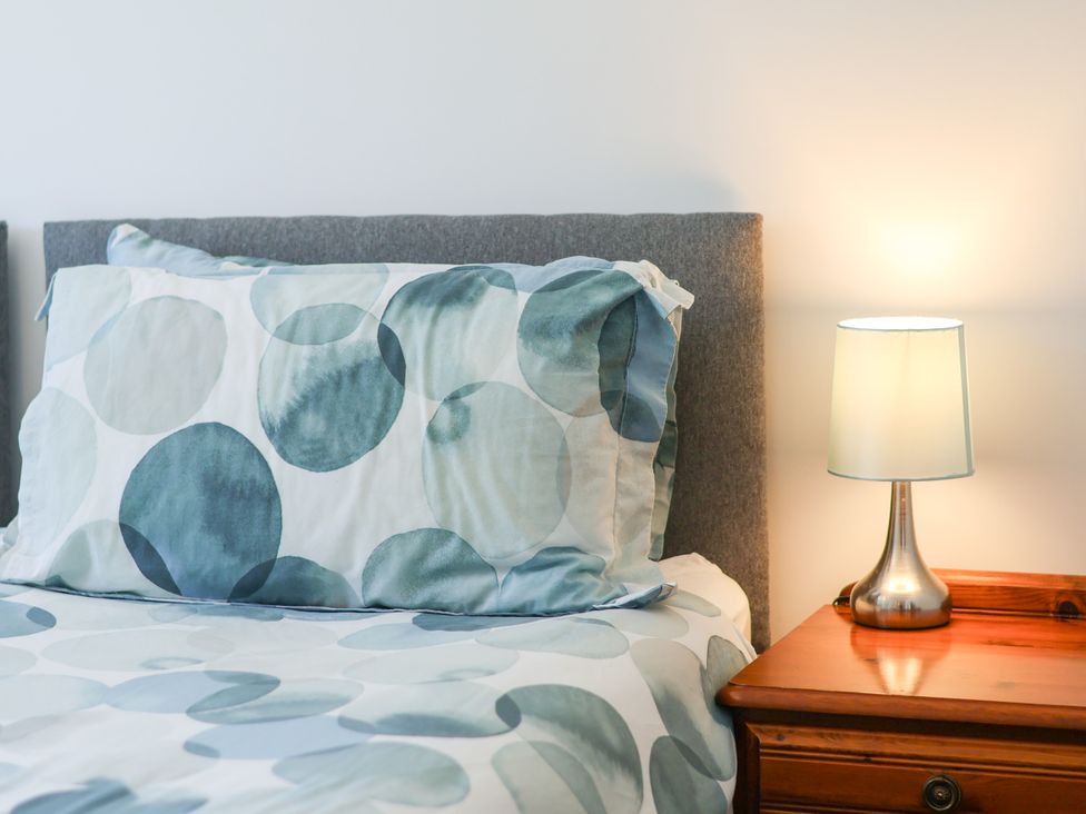 A bed with a pillow and lamp on a nightstand at Castelian in Flamborough